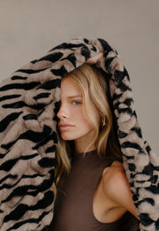 Woman holding blanket tiger print over her head