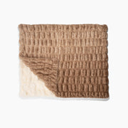 Textured blanket with a gradient from beige to brown on a white background