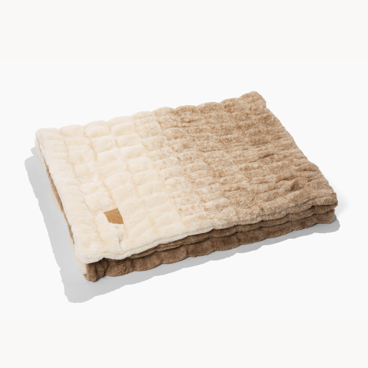 Stack of beige and brown textured blankets on a white background