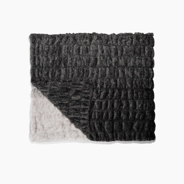 Textured black and gray blanket on a white background