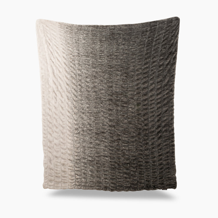 Textured pillow with gradient color from beige to gray on a white background