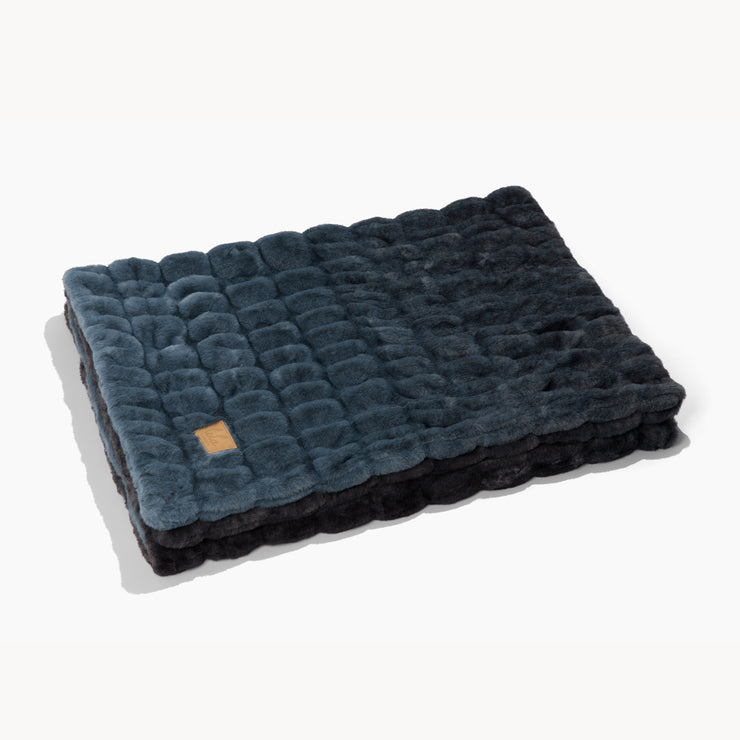 Folded textured blanket with a brand logo on a white background