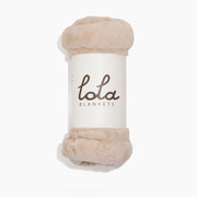 Beige blanket with 'lola blankets' label on a white background