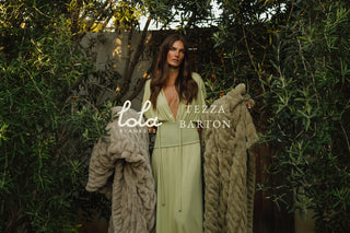 Woman holding a textured blanket with 'Lola Blankets' and 'Tezza Barton' branding against a natural background.